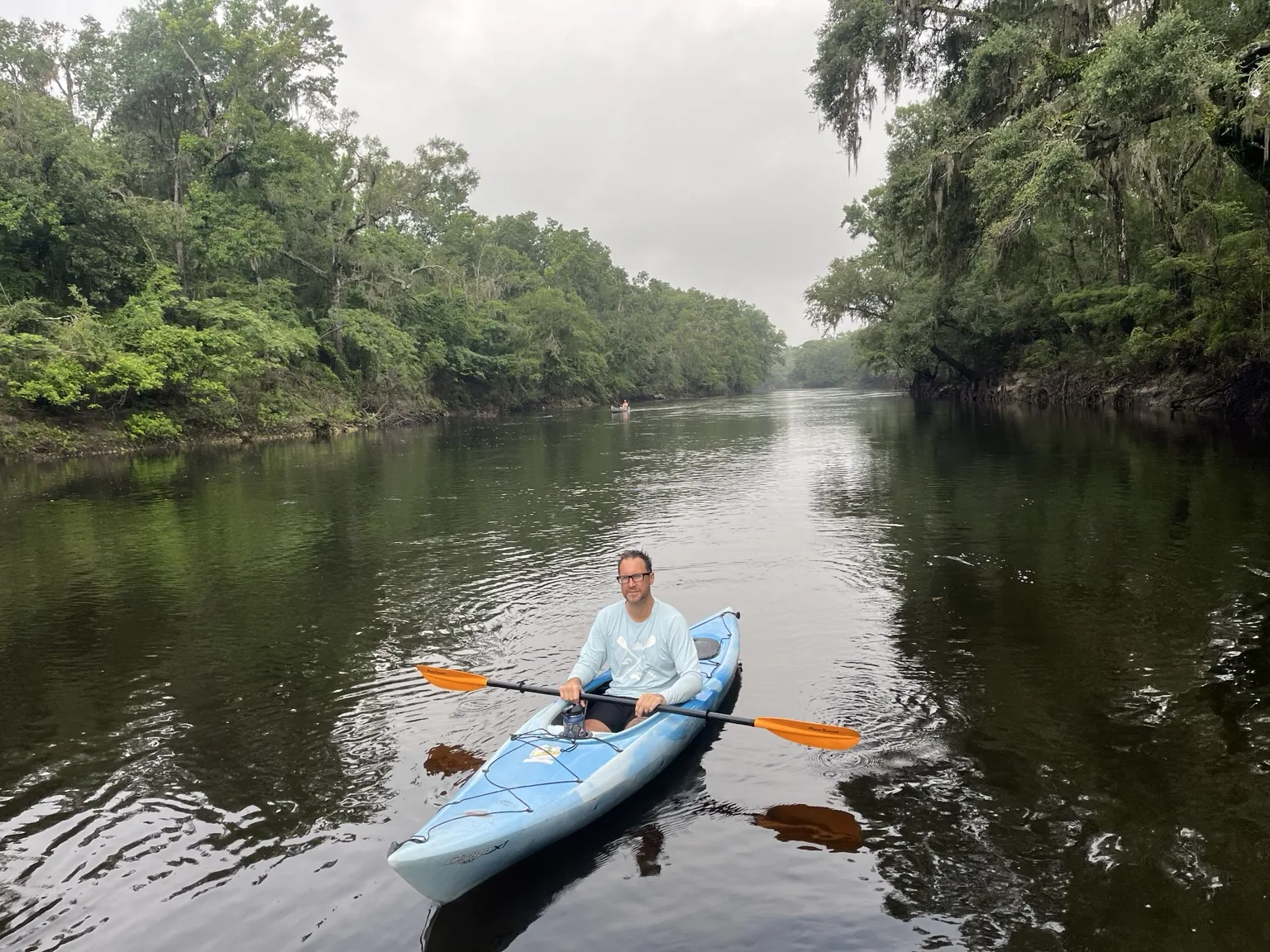 Kayak rental paddler on the Withlacoochee River surrounded by forest